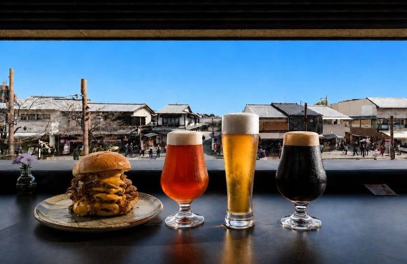 Burger und drei Biere auf Bamboos Terrassentheke mit Blick auf Arashiyama