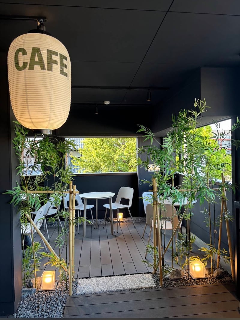 CAFE-Laterne über Tischen zwischen Bambus
